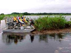 Pushing small floating island away from Highway 60 bridge and flood control structure on Lake Kissimmee (Osceola Co.).